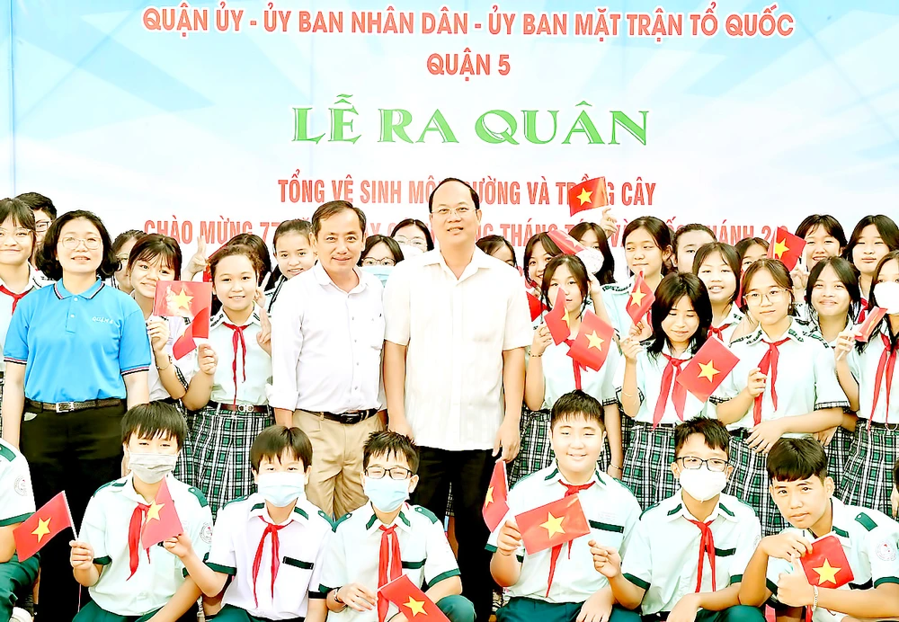 Phó Bí thư Thành ủy TPHCM Nguyễn Hồ Hải cùng các học sinh quận 5 tại lễ ra quân tổng vệ sinh môi trường. Ảnh: VIỆT DŨNG