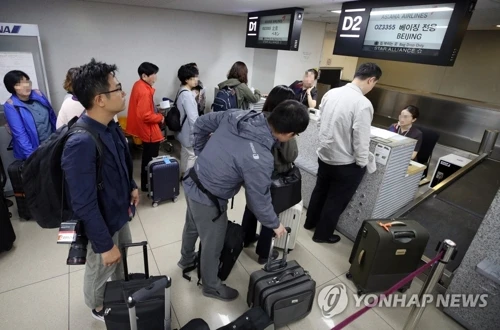 Các phóng viên Hàn Quốc đang làm thủ tục tại sân bay ngày 21-5. Ảnh: YONNHAP