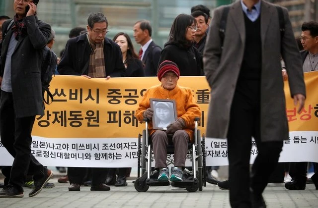  Cụ bà Kim Seong-ju, một trong những nạn nhân được yêu cầu bồi thường,ngồi chờ phán quyết bên ngoài Tòa án ngày 29-11 (Ảnh : Reuters) 