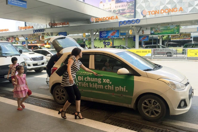 Đa số tài xế xe Grab phải thuê xe khoảng 10 triệu/tháng và đóng phí tầm 25% cho hãng. Trong ảnh: Tài xế xe Grab đón trả khách tại sân bay Tân Sơn Nhất. 