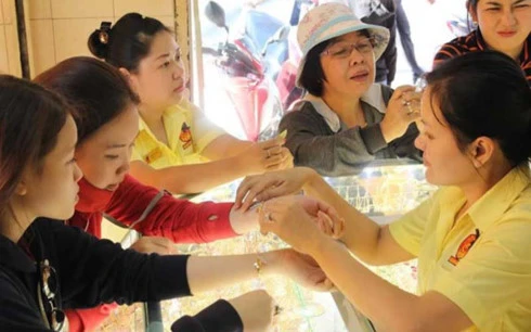 Người dân đang mua bán vàng tại một cửa hàng vàng bạc ở quận Bình Thạnh, TP HCM (Ảnh: HOÀNG GIANG)
