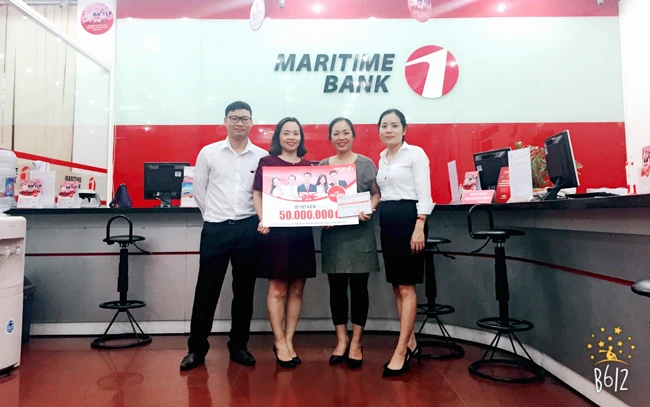 Chị Nguyễn Thị Phượng (thứ hai từ phải sang) đã may mắn nhận được sổ tiết kiệm Maritime Bank 50 triệu đồng đầu tiên của chương trình “Chọn Maritime Bank hôm nay, ngàn ưu đãi mỗi ngày”. 