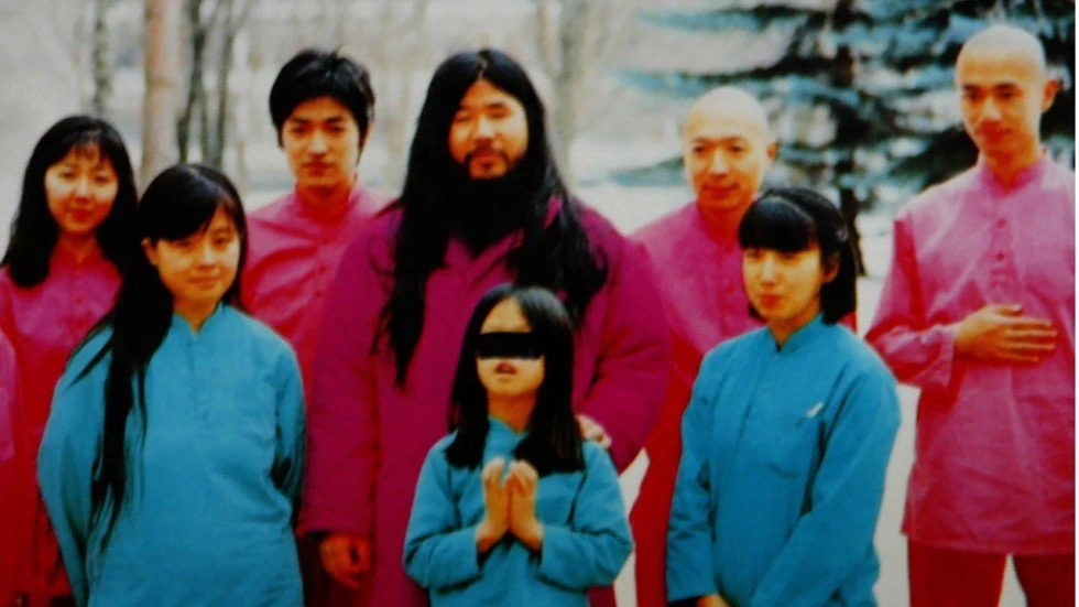 Shoko Asahara (áo hồng giữa ảnh) với vợ Tomoko và 2 con gái (áo xanh, hàng đầu) cùng nhóm các môn đệ. Ảnh: HO / EPA