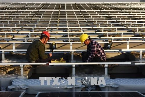 Công nhân làm việc tại Nhà máy điện Mặt trời ở Hoài Nam, tỉnh An Huy, miền đông Trung Quốc tháng 12/2017. (Nguồn: AFP/TTXVN)