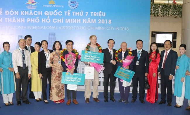 Phó Chủ tịch thường trực UBND TPHCM Lê Thanh Liêm và ông Bùi Tá Hoàng Vũ, Giám đốc Sở Du lịch TPHCM chụp ảnh lưu niệm cùng 3 vị khách đặc biệt trong năm 2018. 