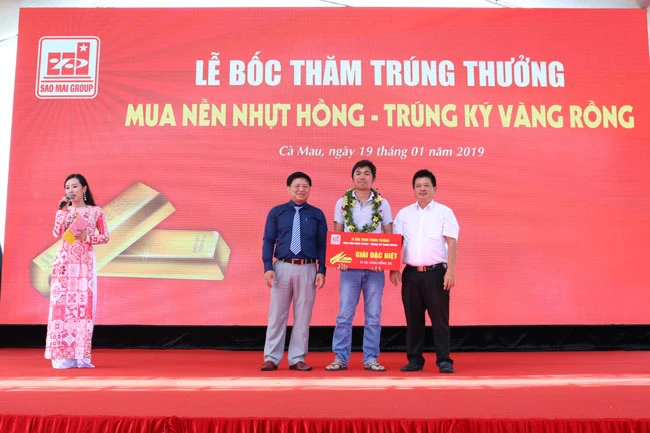 Ông Trương Vĩnh Thành - Phó TGĐ Tập đoàn Sao Mai (áo xanh) trao giải đặc biệt cho khách hàng Trần Thanh Tuấn.