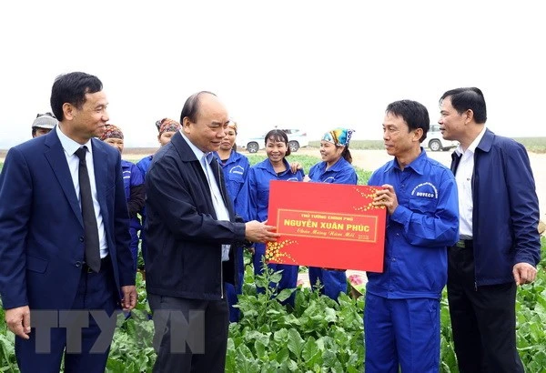 Thủ tướng Nguyễn Xuân Phúc tặng quà công nhân Công ty Cổ phần thực phẩm xuất khẩu Đồng Giao. (Ảnh: Thống Nhất/TTXVN)