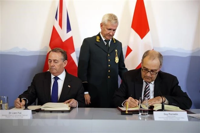 Bộ trưởng Thương mại Anh Liam Fox (trái) và Bộ trưởng Kinh tế Thụy Sĩ Guy Parmelin (phải) ký thỏa thuận duy trì hoạt động thương mại Anh - Thụy Sĩ tại Bern ngày 11/2/2019. (Ảnh: AFP/ TTXVN)