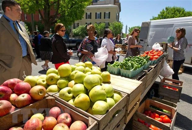 Khách hàng mua rau củ quả tại một chợ nông trại ở Washington, DC. (Ảnh: AFP/TTXVN)