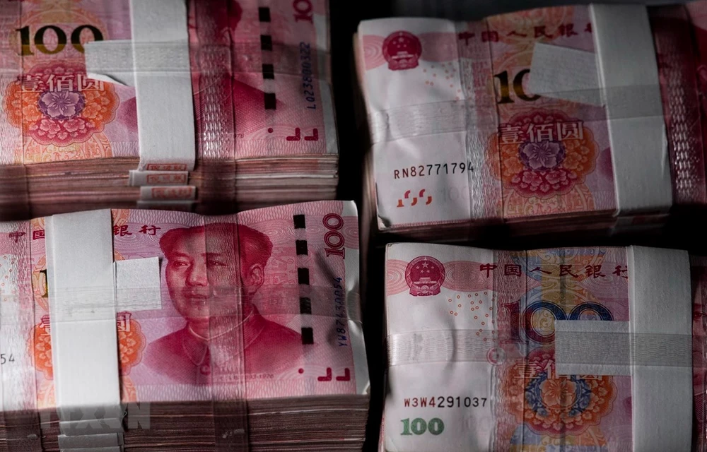Đồng tiền mệnh giá 100 nhân dân tệ tại Thượng Hải, Trung Quốc. (Ảnh: AFP/TTXVN)