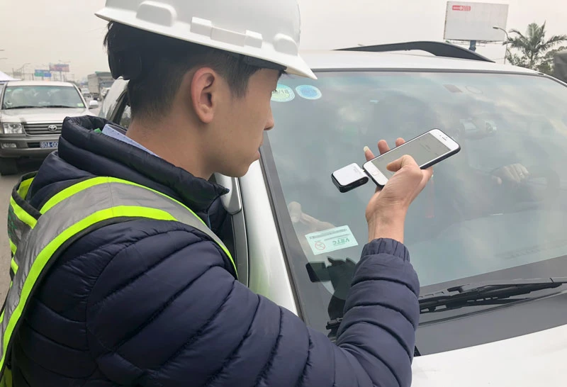 Nhân viên VETC thực hiện dán thẻ e-tag lên ô tô. Ảnh: VGP/Phan Trang.