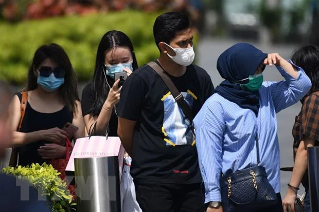 Người dân đeo khẩu trang phòng dịch viêm đường hô hấp cấp do virus COVID-19 tại Singapore. (Ảnh: AFP/TTXVN)
