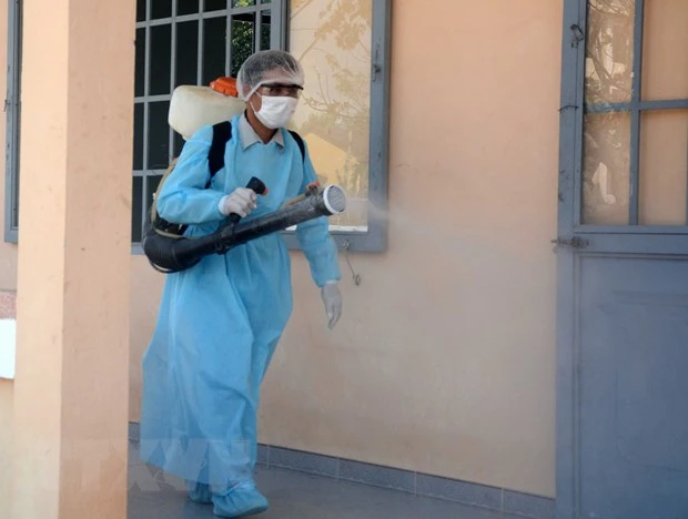 Nhân viên y tế thực hiện phun thuốc sát khuẩn tại Trung tâm Huấn luyện dự bị động viên Đồng Nghệ (xã Hòa Khương, huyện Hòa Vang, Đà Nẵng) đang thực hiện cách ly 69 người Việt Nam Daegu (Hàn Quốc) trở về. (Ảnh: Văn Dũng/TTXVN)