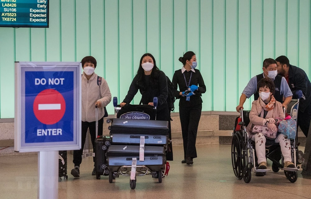 Người dân đeo khẩu trang để phòng tránh lây nhiễm COVID-19 tại sân bay ở Los Angeles, California, Mỹ, ngày 29/2/2020. (Ảnh: AFP/TTXVN)