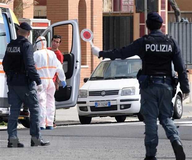 Cảnh sát và nhân viên y tế được triển khai tới nơi ở của bệnh nhân nhiễm COVID-19 tại Rome, Italy. (Ảnh: THX/TTXVN)