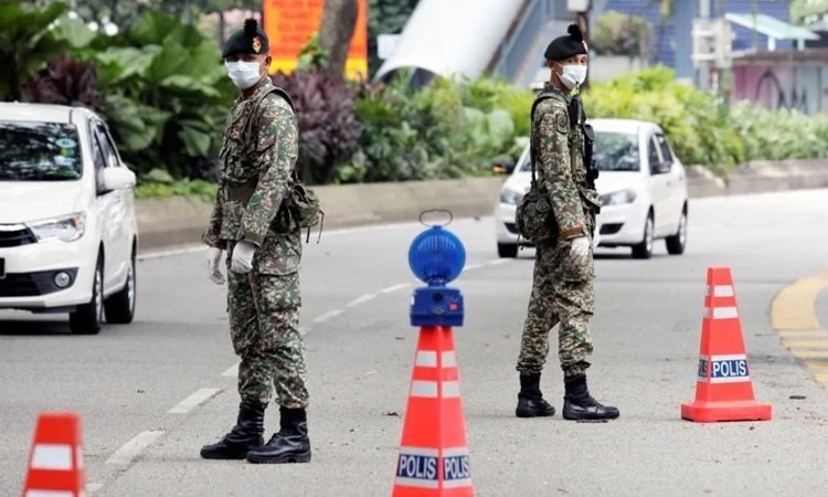 Các binh sĩ canh gác trên một con đường ở thủ đô Kuala Lumpur, Malaysia, ngày 22/3. Ảnh:Reuters.