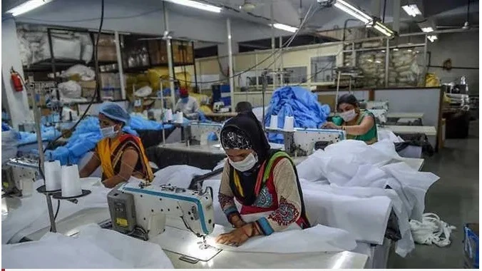 Công nhân may quần áo bảo hộ y tế tại một cơ sở của thành phố Ahmedabad, Ấn Độ, Ảnh AFP