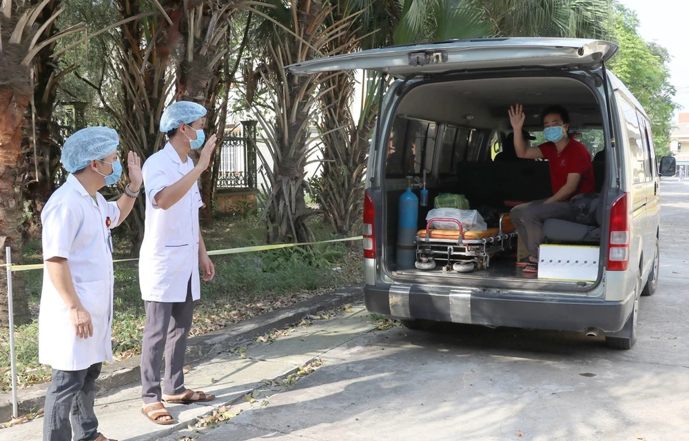 Các y bác sỹ Bệnh viện Đa khoa huyện Kim Sơn chào tạm biệt bệnh nhân nhiễm Covid-19 cuối cùng điều trị tại Ninh Bình được xuất viện. (Ảnh: Thùy Dung/TTXVN)
