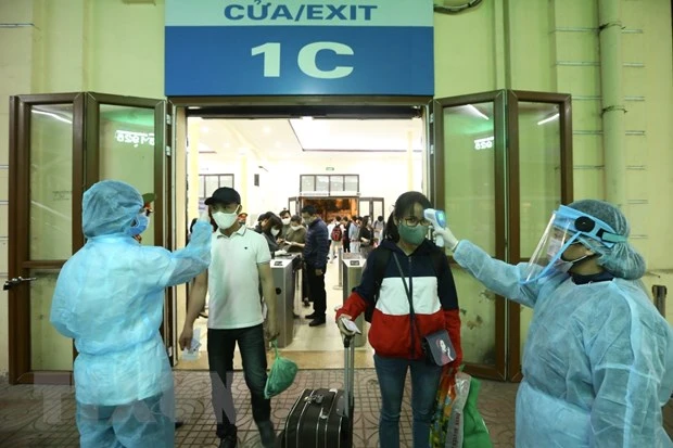 Kiểm tra thân nhiệt cho hành khách tại Ga Hà Nội. (Ảnh: TTXVN)