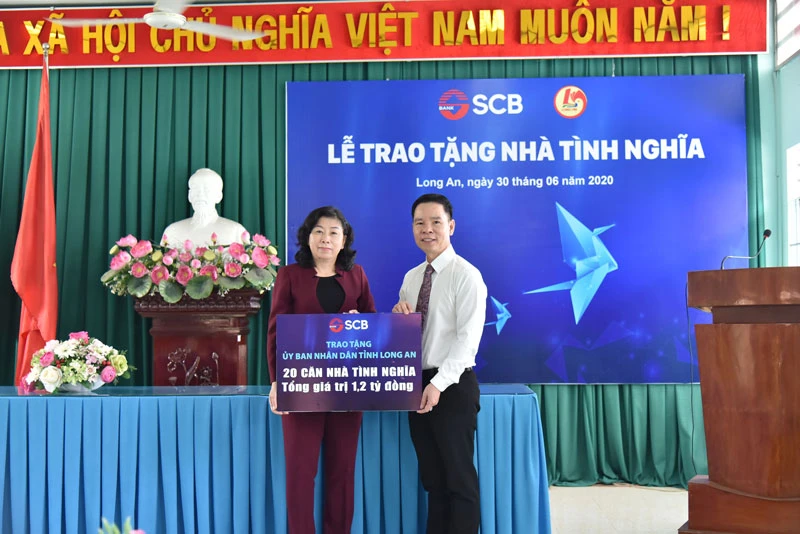 Ông Đinh Văn Thành – Chủ tịch HĐQT SCB trao bảng tượng trưng trao 20 căn nhà tình nghĩa tại Long An.