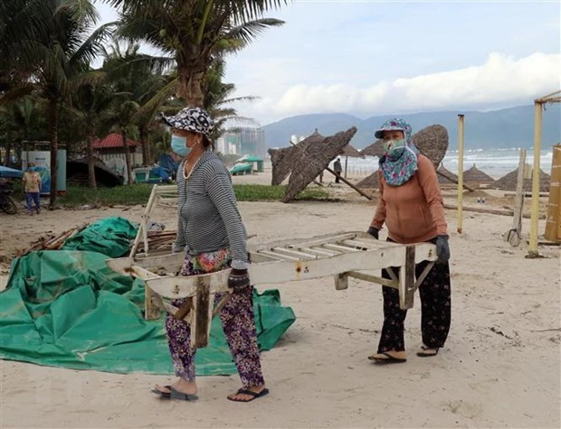 Người dân Đà Nẵng vận chuyển vật dụng kinh doanh trên các bãi biển đưa lên bờ để tránh thiệt hại khi bão số 9 đổ bộ. (Ảnh: Trần Lê Lâm/TTXVN)