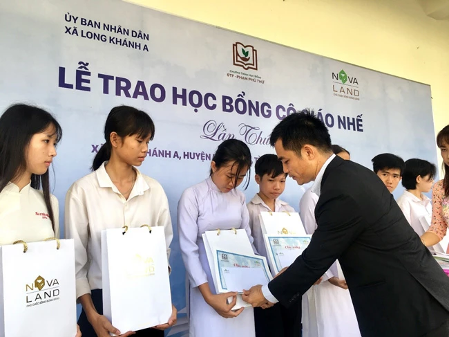 Đại diện Tập đoàn Novaland trao học bổng cho các em học sinh có hoàn cảnh khó khăn xã Long Khánh