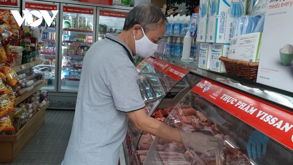 Khách hàng đang lựa chọn thịt lợn tại cửa hàng.