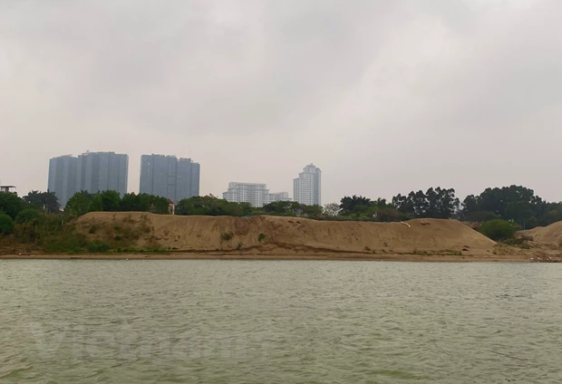 Nhiều khu vực đã xuất hiện các bãi tập kết cát, hàng quán ở sát ven hai bờ sông Hồng. (Ảnh: Hùng Nguyễn/Vietnam+)
