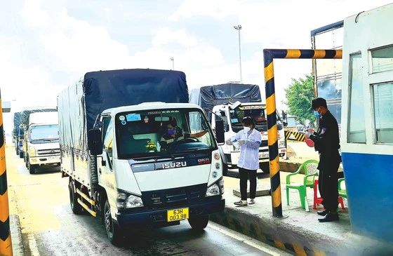 Kiểm tra các xe tải vận chuyển hàng hóa qua chốt Thân Cửu Nghĩa, tỉnh Tiền Giang. Ảnh: NGỌC PHÚC