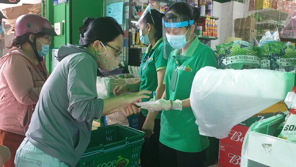 Tại Co.op Food Chu Văn An, khách muốn mua thì tự lựa chọn sản phẩm trước cửa hoặc nói món cần mua để nhờ nhân viên "đi chợ giúp" do bên trong và bên ngoài được ngăn cách - Ảnh: N.TRÍ