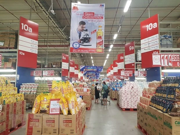Người dân đi mua hàng tại siêu thị trên phố Hoàng Mai, tối 23/7. (Ảnh: Phương Anh/TTXVN)