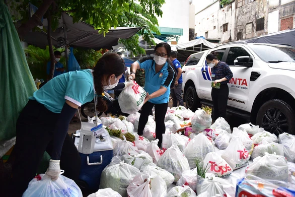 Đoàn viên phường 11, quận Tân Bình mang đồ được đặt đến cho hộ dân trên đường Võ Thành Trang - Ảnh: NGỌC PHƯỢNG