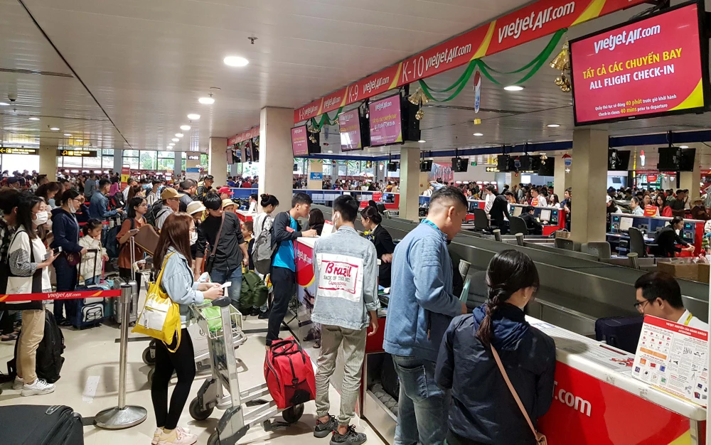Việc áp giá sàn khiến người tiêu dùng mất cơ hội chọn vé máy bay giá rẻ. Trong ảnh, người dân làm thủ tục tại sân bay Tân Sơn Nhất vào dịp tết - Ảnh: NGỌC HIỂN