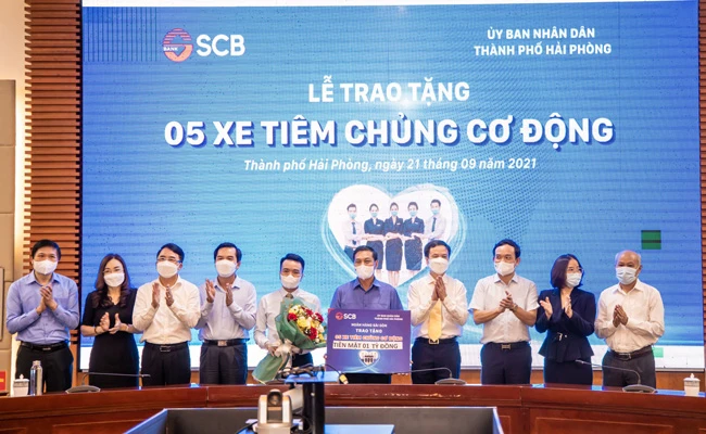 Đại diện SCB trao bảng tượng trưng tặng 05 chiếc xe tiêm chủng cơ động