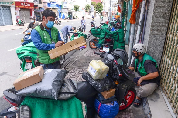 Shipper lấy hàng trên đường Nguyễn Kiệm, quận Phú Nhuận (TP.HCM) để giao cho khách vào sáng 20-9 - Ảnh: QUANG ĐỊNH
