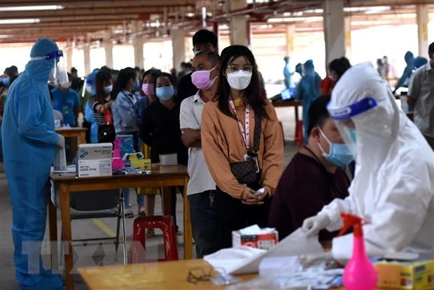Người lao động tại Công ty Pousung Việt Nam làm các thủ tục trước khi vào nhà máy làm việc. (Ảnh: Công Phong/TTXVN)