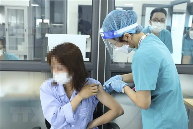 Đội tiêm chủng của Bệnh viện Đại học Y Hà Nội tiêm vaccine phòng COVID-19 cho người bệnh và người nhà đủ điều kiện tiêm chủng chuyển đến từ bệnh viện Việt Đức. (Ảnh: Đức Trọng/TTXVN phát)