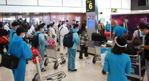 Tất cả hành khách từ TP.HCM ra Hà Nội đều phải tiêm đủ 2 mũi vắc xin, xét nghiệm âm tính với SARS-CoV-2 nhưng nhiều người vẫn mặc đồ phòng dịch rất cẩn thận - Ảnh: TUẤN PHÙNG
