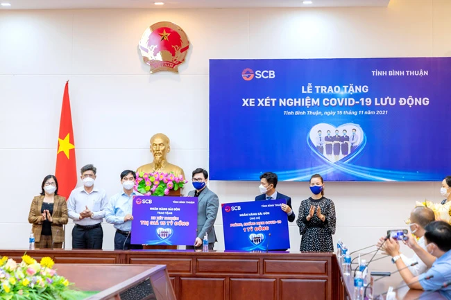 Ông Trương Khánh Hoàng- Q.TGĐ SCB trao bảng tượng trưng xe xét nghiệm Covid-19 lưu động có giá trị 15 tỷ đồng và 01 tỷ đồng cho Quỹ cứu trợ của UBMTTQ Việt Nam tỉnh Bình Thuận