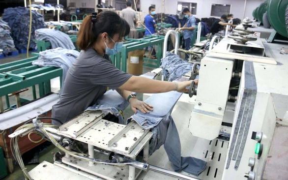 Các công nhân tại nhà máy dệt may ở TP Thủ Đức tăng ca sản xuất, tăng thêm 20% công suất để kịp các đơn hàng cuối năm - Ảnh: NGỌC HIỂN
