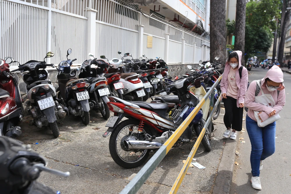 Tại Bệnh viện Hùng Vương (Q.5, TP.HCM), người đi bộ phải đi xuống lòng đường vì vỉa hè bị lấn chiếm làm bãi giữ xe