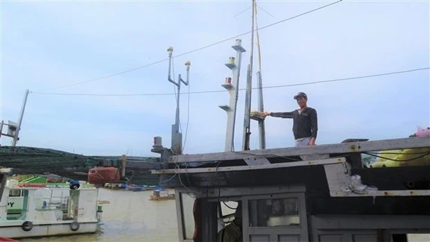 Ngư dân lắp đặt thiết bị giám sát hành trình cho tàu cá có chiều dài từ 15m trở lên theo quy định. (Ảnh: Tường Quân/TTXVN)