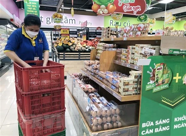 Nhân viên siêu thị Thành phố Hồ Chí Minh cung ứng hàng hóa lên quầy, kệ phục vụ người dân mua sắm. (Ảnh: Mỹ Phương/TTXVN)