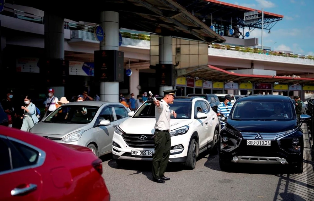 Lực lượng An ninh kiểm soát sân đỗ ôtô tăng cường điều tiết, phân luồng phương tiện tại sân bay. (Ảnh: CTV/Vietnam+)