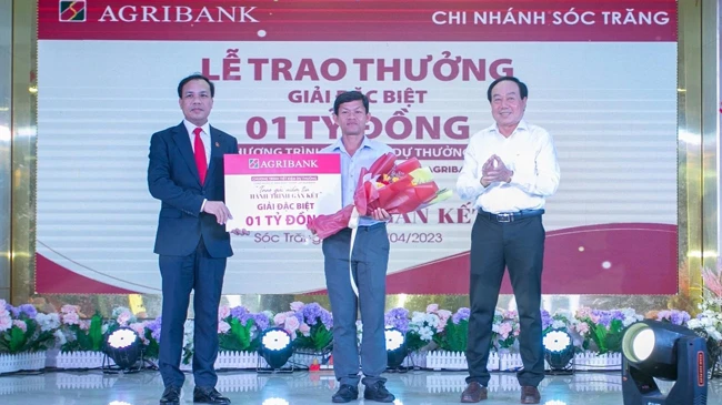 Đại diện lãnh đạo Agribank, Phó Tổng giám đốc Lê Hồng Phúc trao 1 tỷ đồng cho khách hàng trúng giải Đặc biệt.