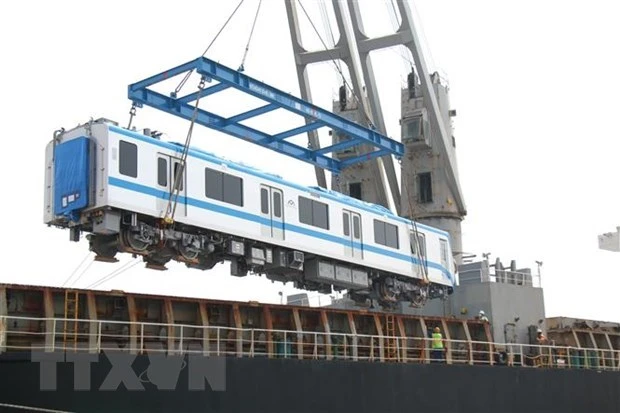 Toa xe đầu tiên của đoàn tàu số 12 metro Bến Thành-Suối Tiên được cầu khỏi tàu vận chuyển. (Ảnh: Tiến Lực/TTXVN)