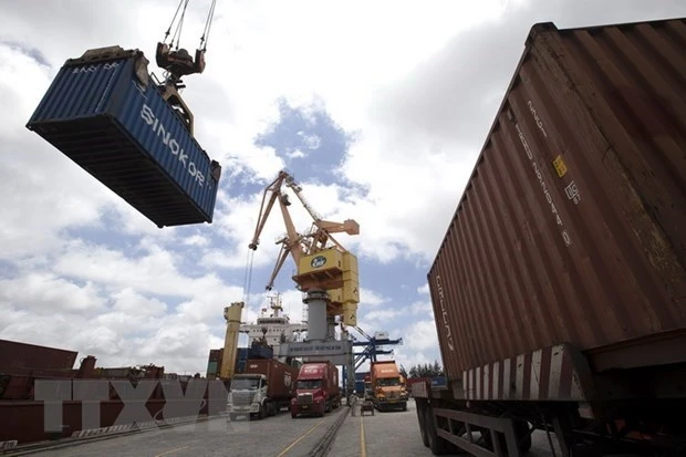 Các container được bốc xếp từ xe chở chuyên dụng lên tàu chở hàng. (Ảnh: Tuấn Anh/TTXVN)