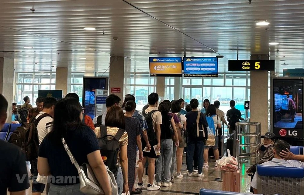 Hành khách làm thủ tục lên chuyến bay tại Cảng Hàng không quốc tế Tân Sơn Nhất. (Ảnh: PV/Vietnam+)