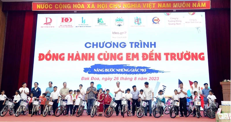 Đại biểu và đại diện các công ty trao xe đạp cho học sinh.