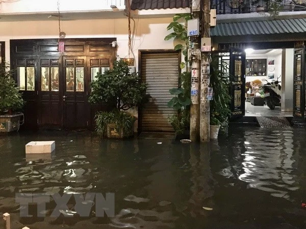 Nước ngập tràn vào nhà dân tại một tuyến hẻm trên đường Trần Xuân Soạn, quận 7, TP.HCM, chiều tối 1/10 vừa qua. (Ảnh: Hồng Giang/TTXVN)